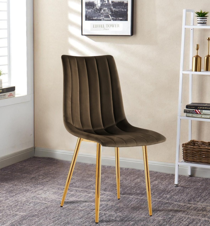 Krzesło tapicerowane Alan brązowe (czekoladowe), welurowe, nogi złote. Zdjęcie przedstawia krzesło w salonie.  Widok z przodu, bokiem.